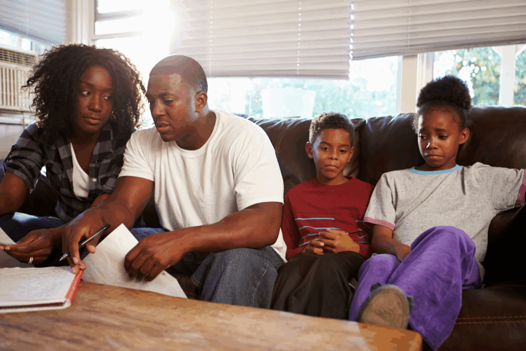 A family sitting together reviewing documents with concerned expressions, reflecting discussions about a loved one’s ongoing parole review in Texas.