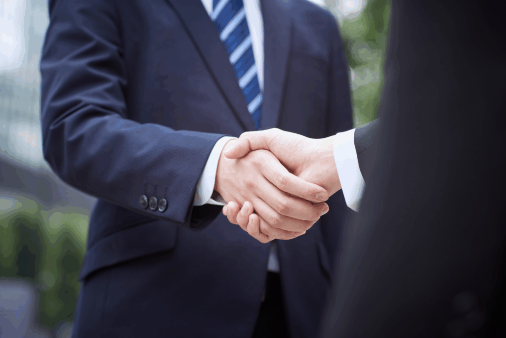 Two professionals in suits shaking hands, symbolizing trust, integrity, and ethical commitment from a Texas parole attorney.